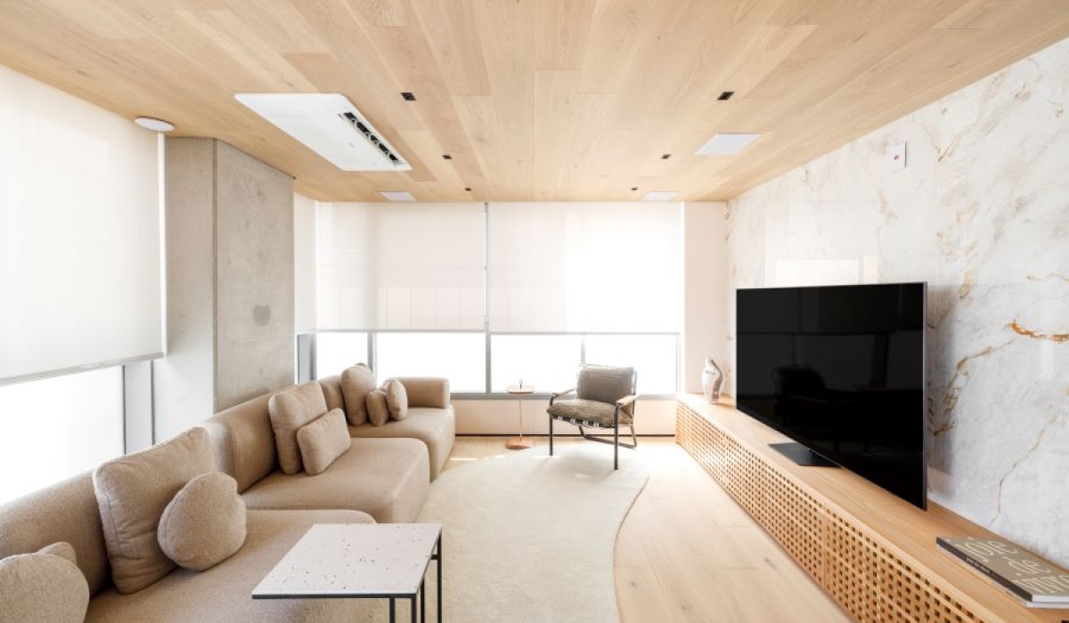 Apartamento dúplex de 170m² apresenta uma paleta de cores quentes e abundância de madeira
